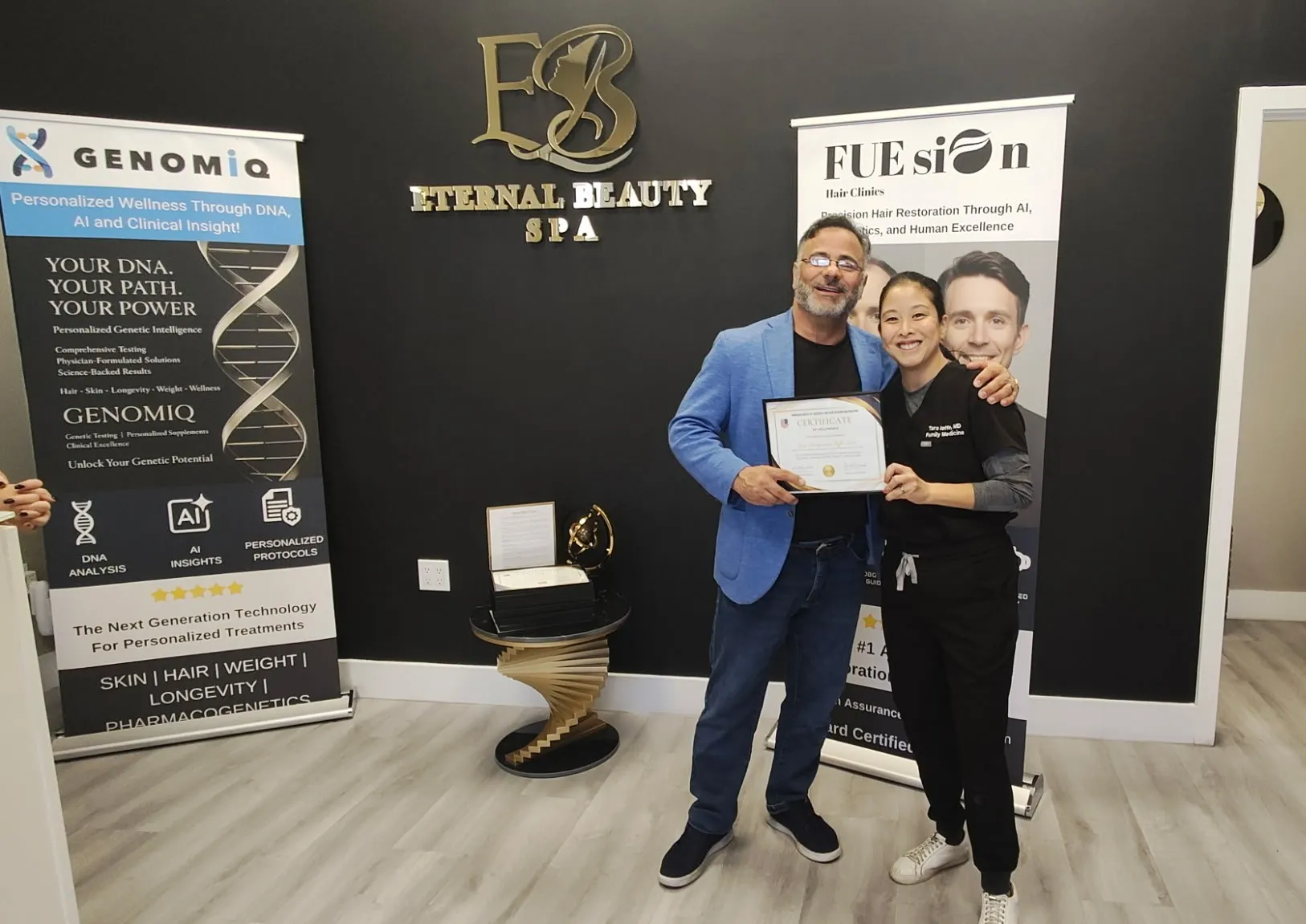 Tara with Dr. Gran standing next to FUE is On signage